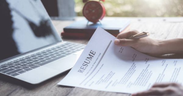 Business man review his resume application on desk, laptop computer, job seeker